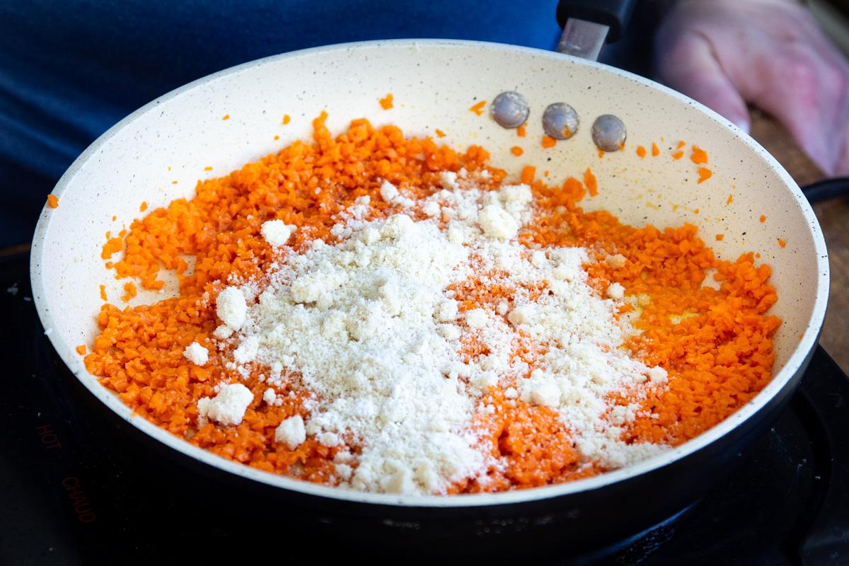 shredded carrots and almond flour in a sauteeing pan