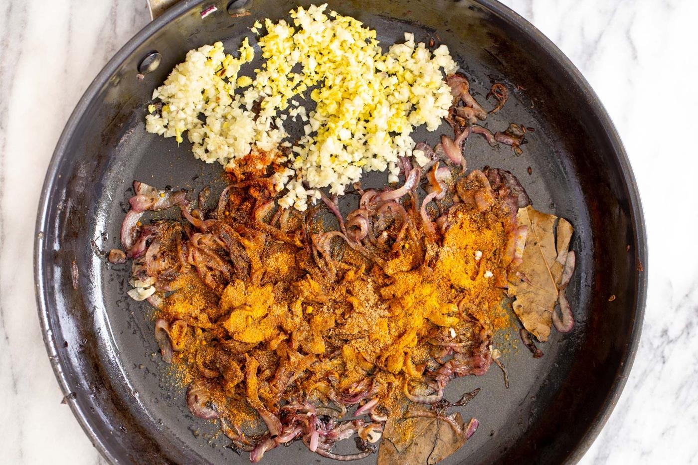 minced garlic, ginger and onions as well as ground spices in a saucepan