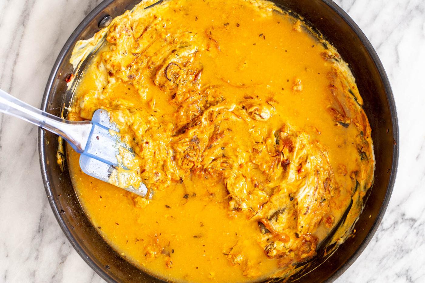 creamy onion gravy in a black saucepan