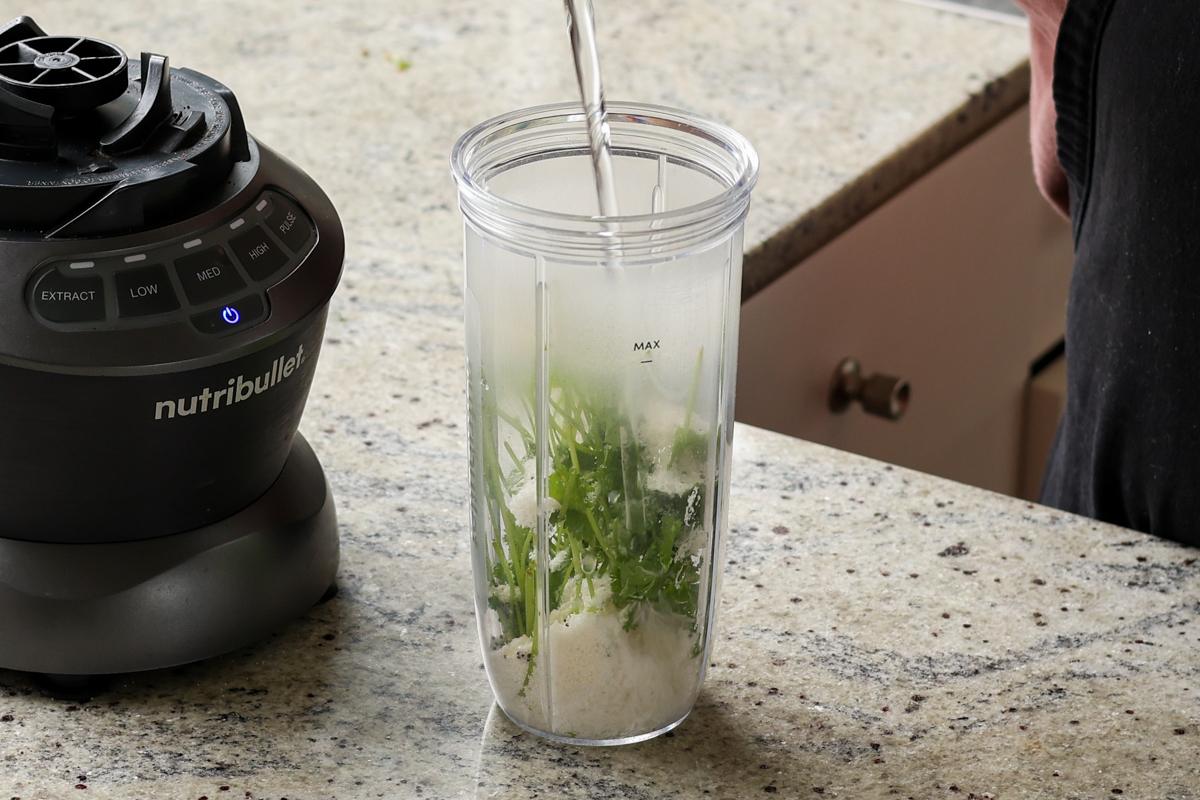adding coconut chutney ingredients to the blender