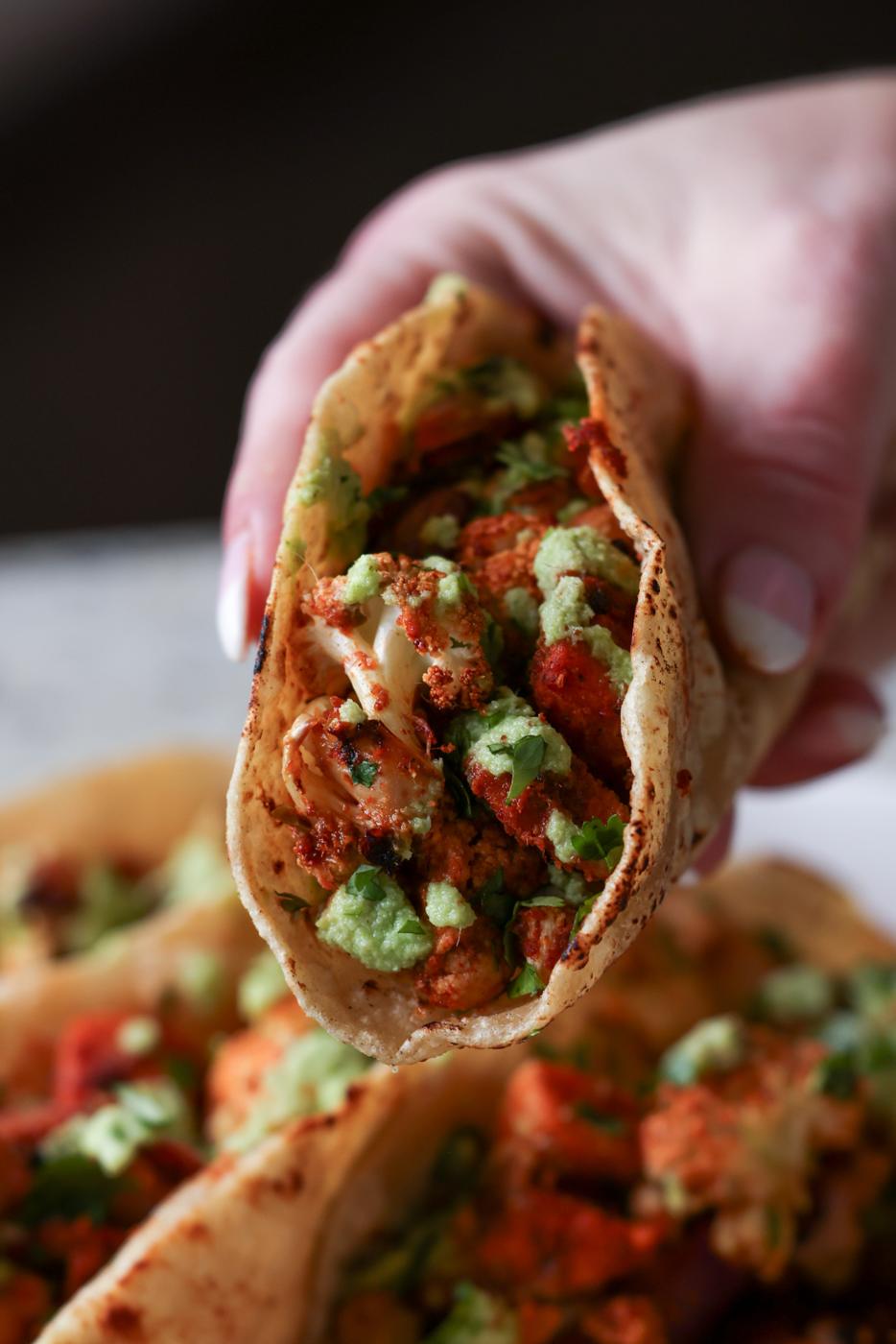 hand holding a cauliflower sweet potato taco