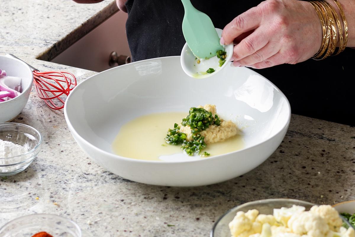 adding tikka masala marinade ingredients to a bowl