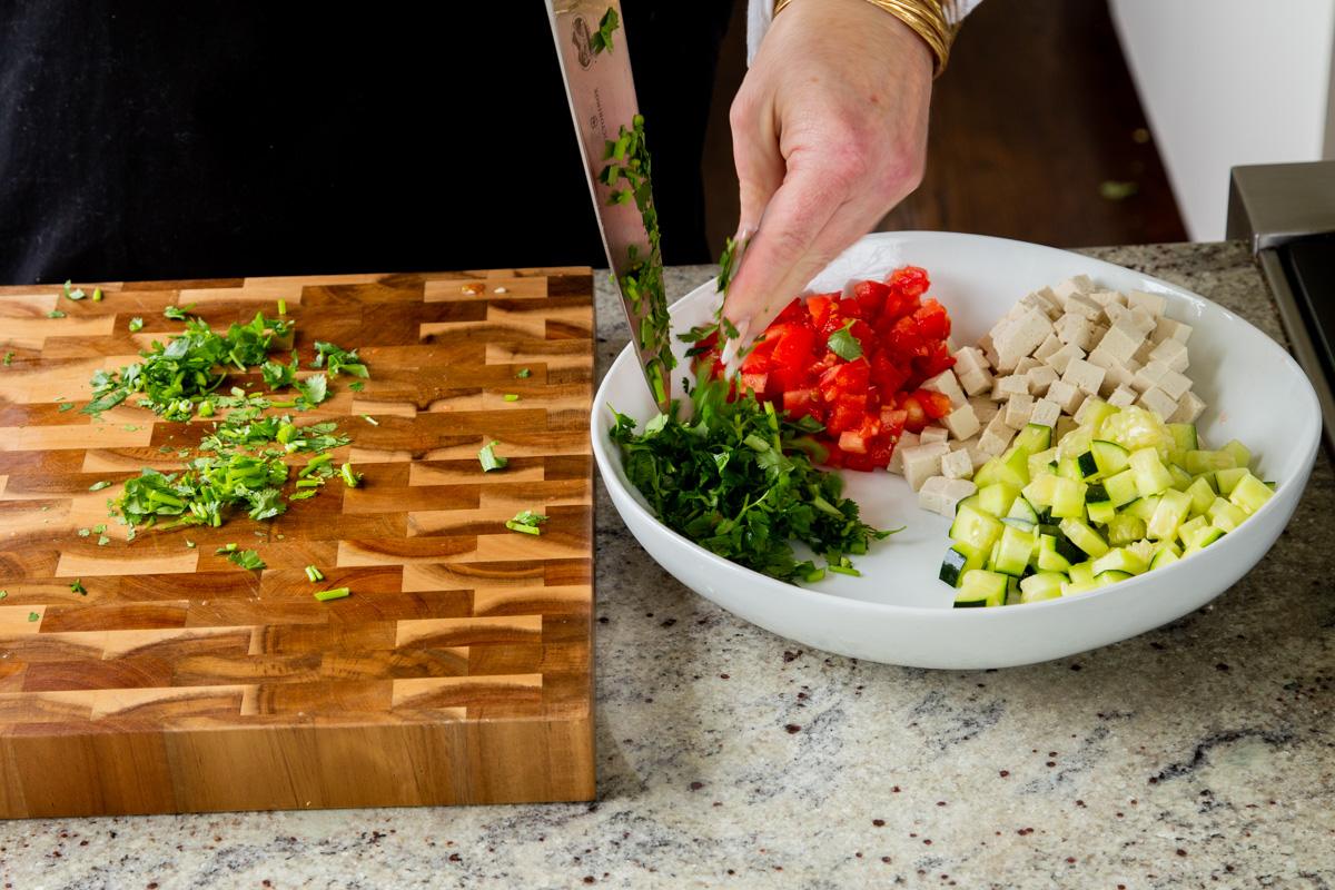 adding cilantro to the salad bowl