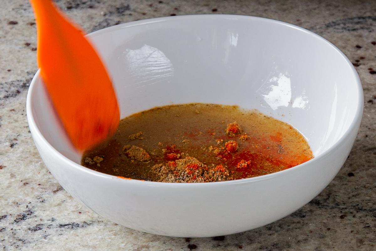 adding spices to the bowl of lime juice and maple syrup