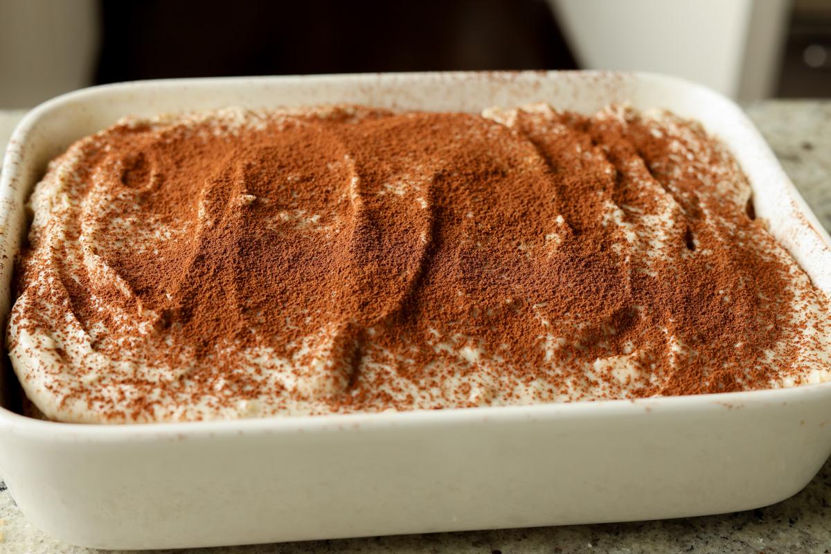 chai tiramisu cake after dusting with cocoa and cinnamon