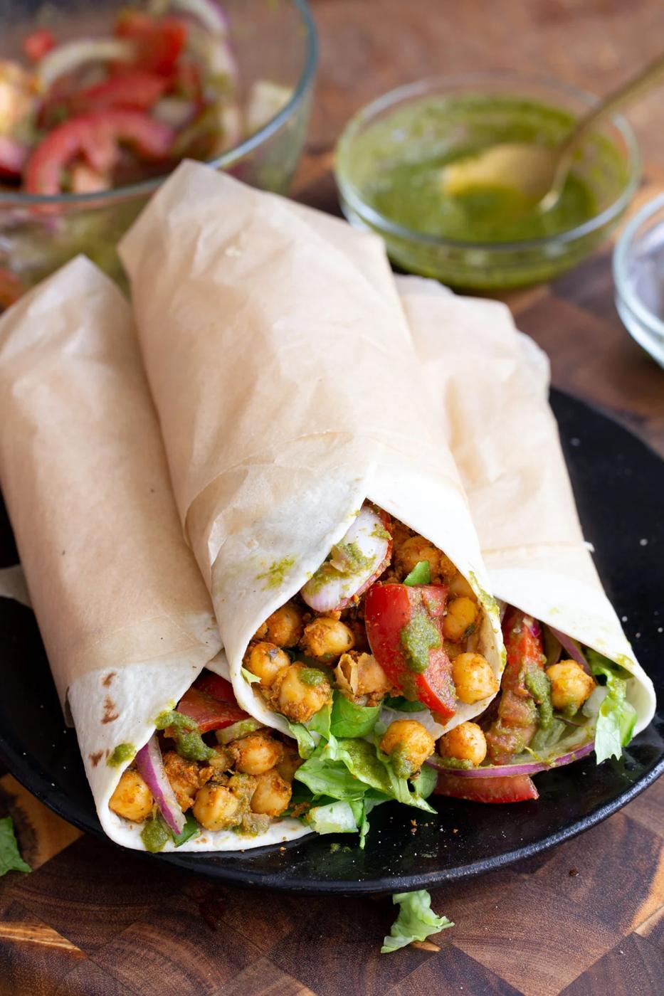 three Indian spiced chickpea wraps filled with tomtoes and lettuce