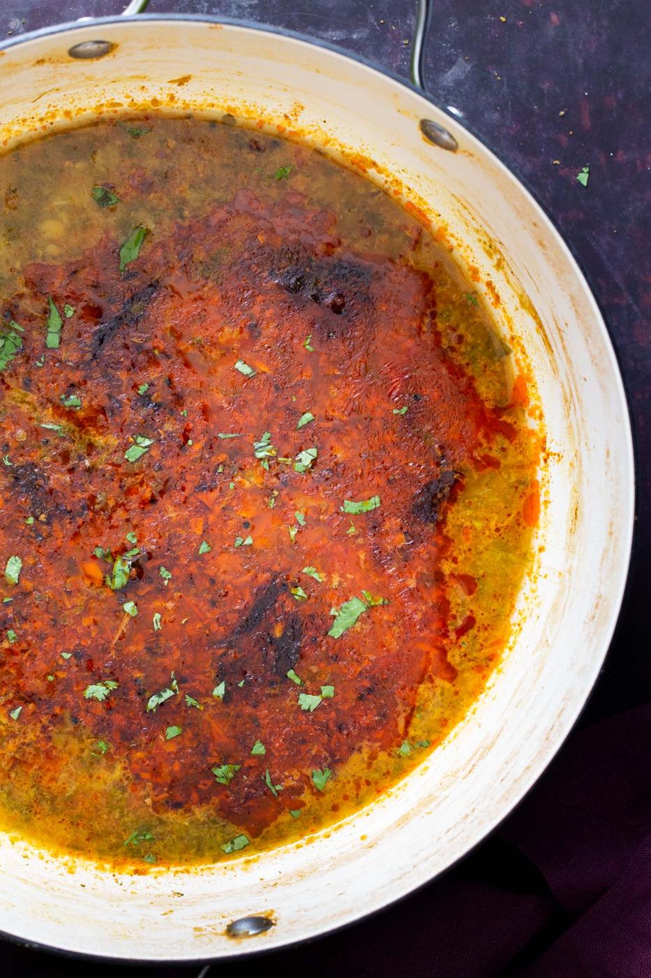 overhead shot of a pot of chataka dal with seasoned oil