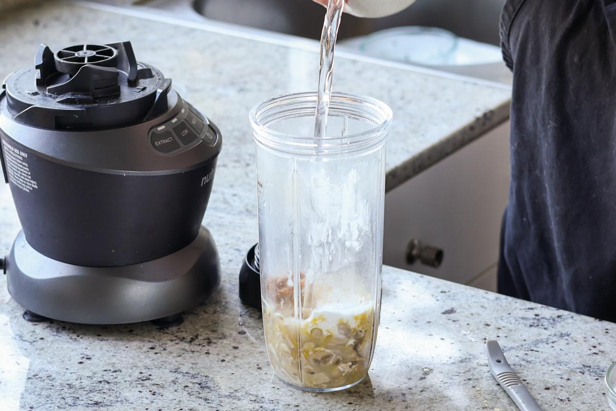 adding cashew cream ingredients to the blender