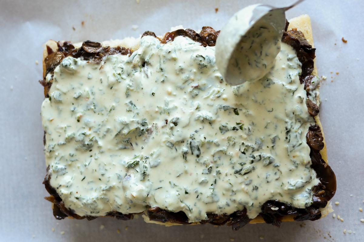 spreading the spinach-cashew cream mixture onto the mushroom sliders