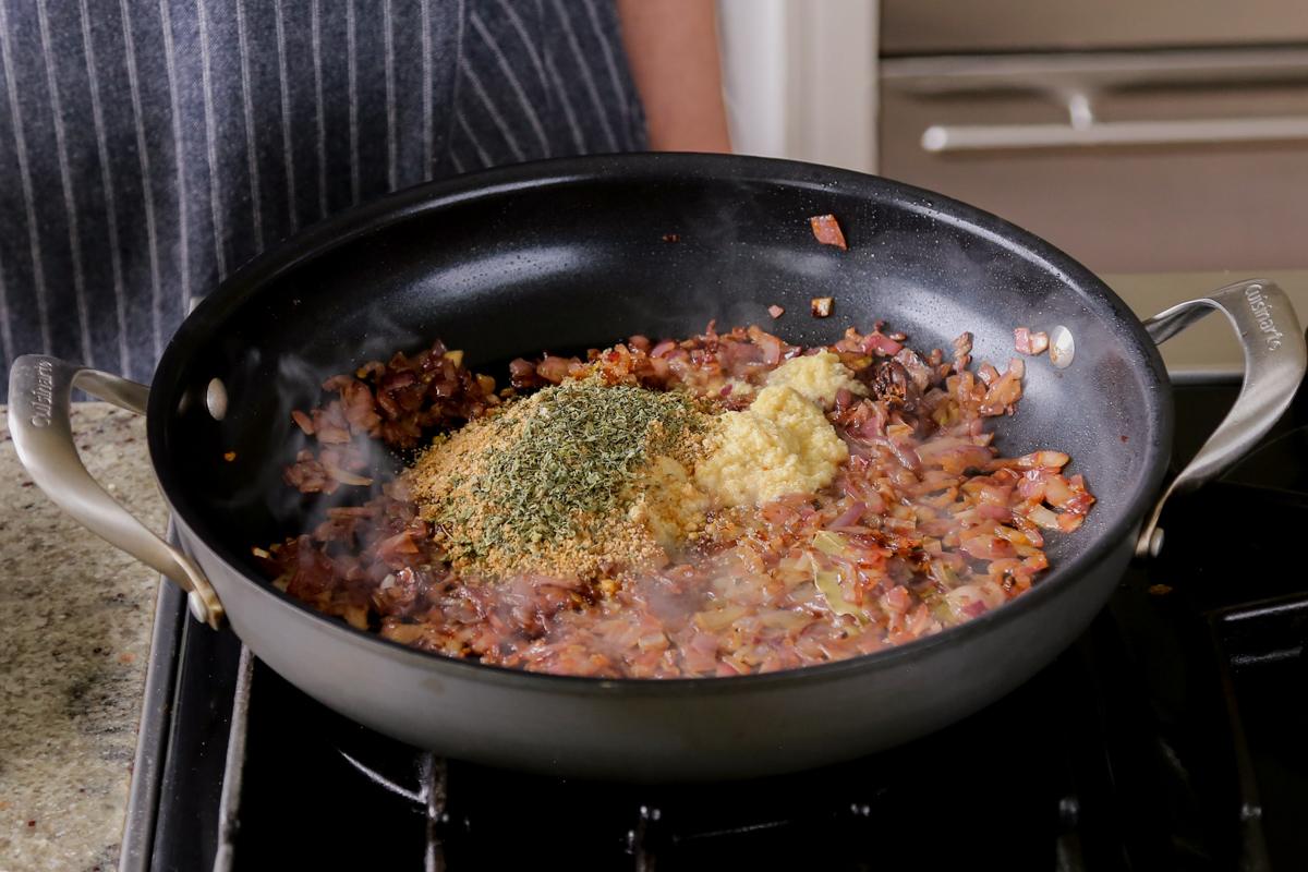 adding spices and more aromatics to the cooked onion