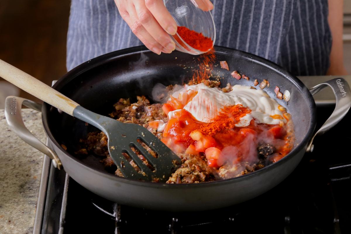 adding Kashmiri chili powder to the pan