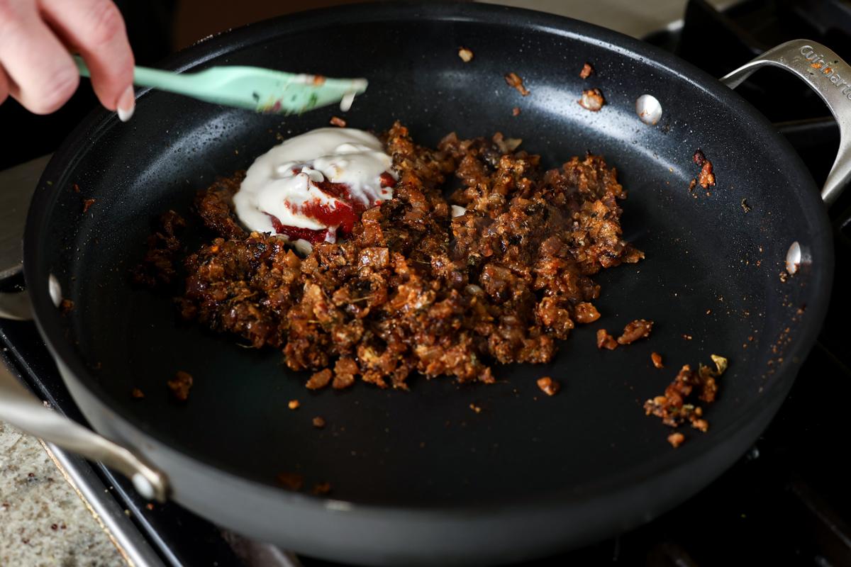 adding tomato paste and non-dairy yogurt to the pan