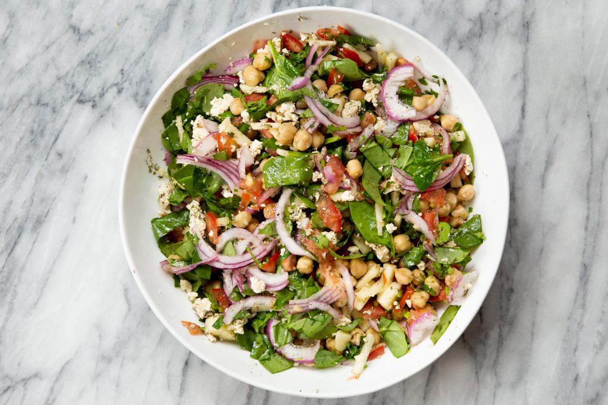 freshly tossed chickpea salad in a white salad bowl