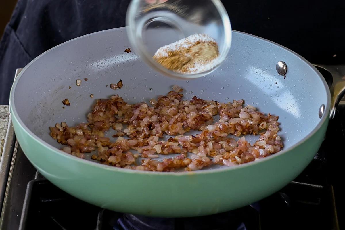 adding salt and spices to cooked onions