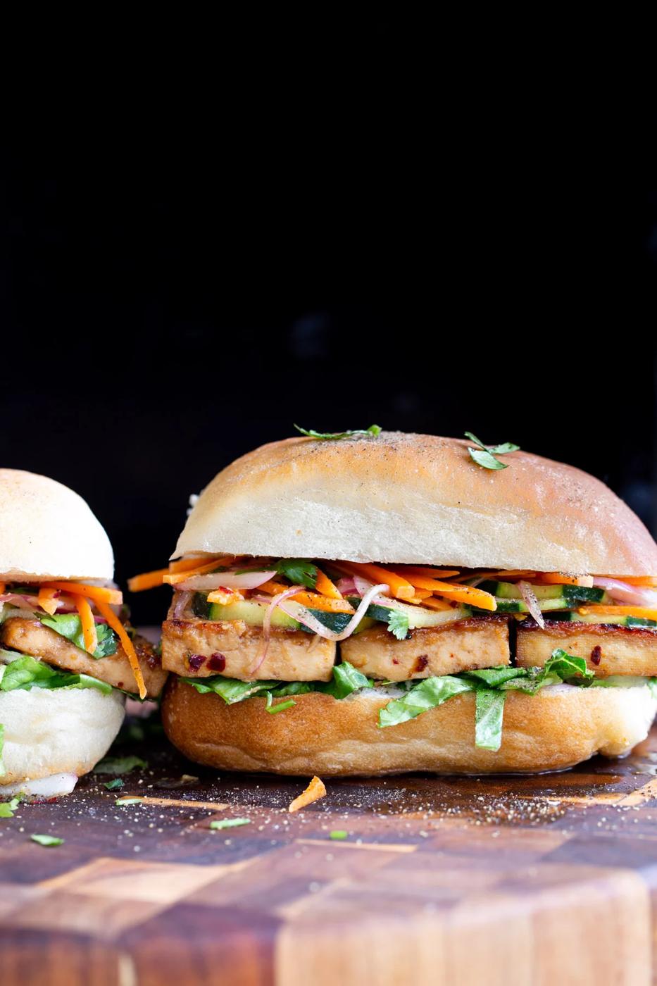 side view of a vegan chili garlic tofu sandwich on a chopping board