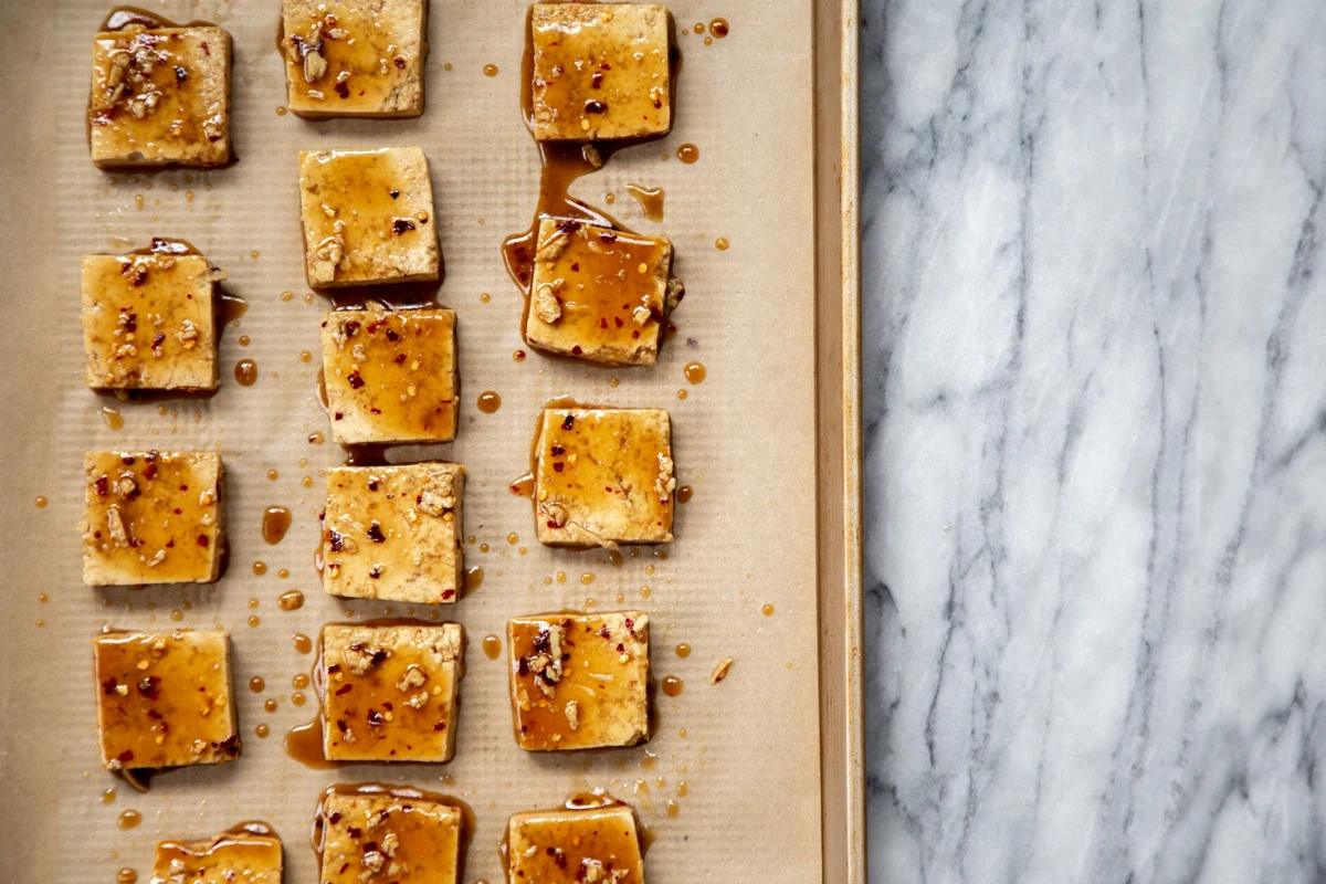 marinated tofu cubes on a sheetpan ready for baking