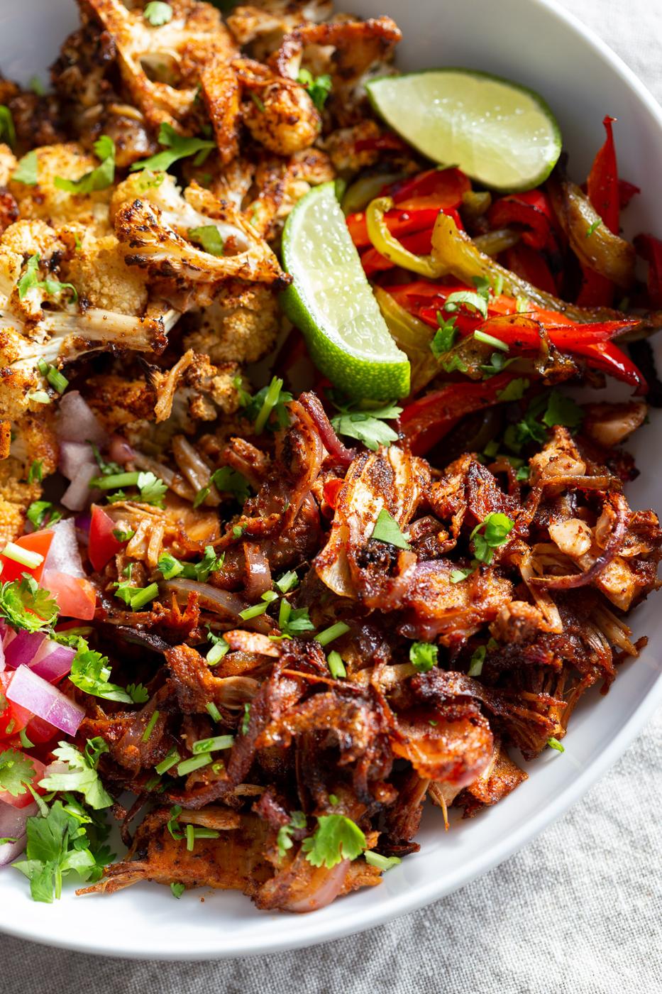 Chili Lime Roasted Veggies & Jackfruit in a White Bowl to be drizzled with jalapeno cream sauce