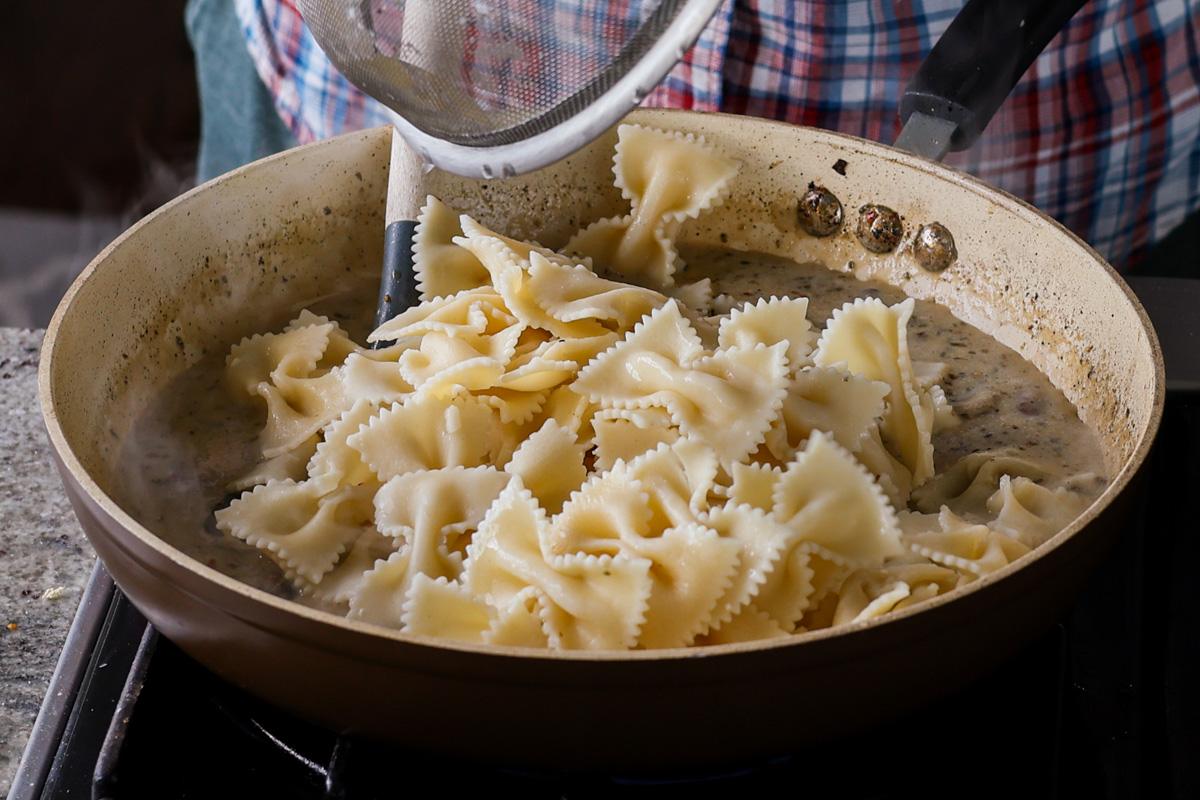 adding farfalle pasta to the pan
