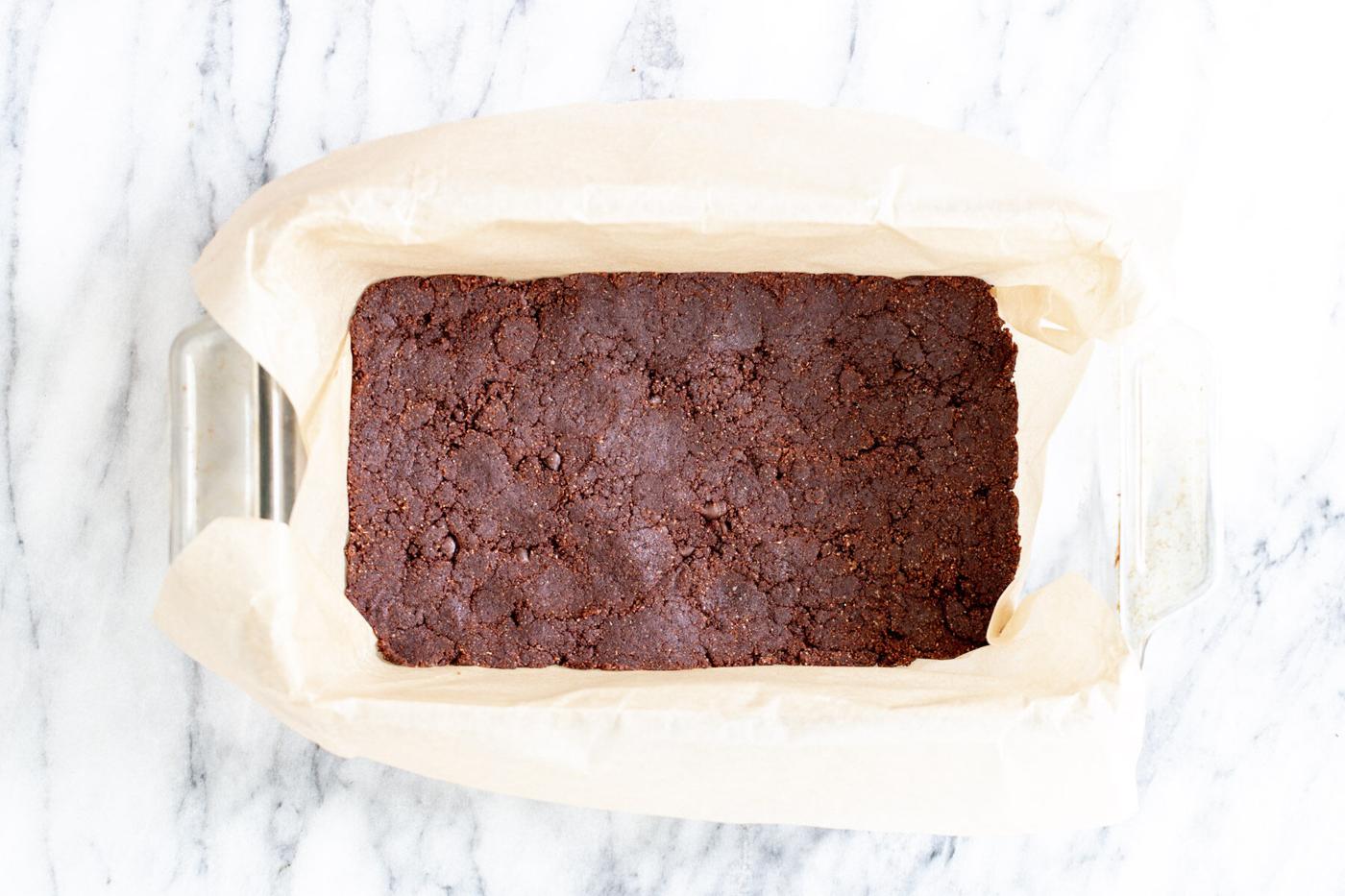 vegan cookie dough pressed into a loaf pan to make vegan ice cream sandwiches