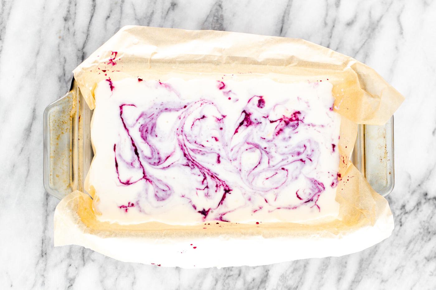 vanilla ice cream base in a loaf pan swirled with blueberry compote
