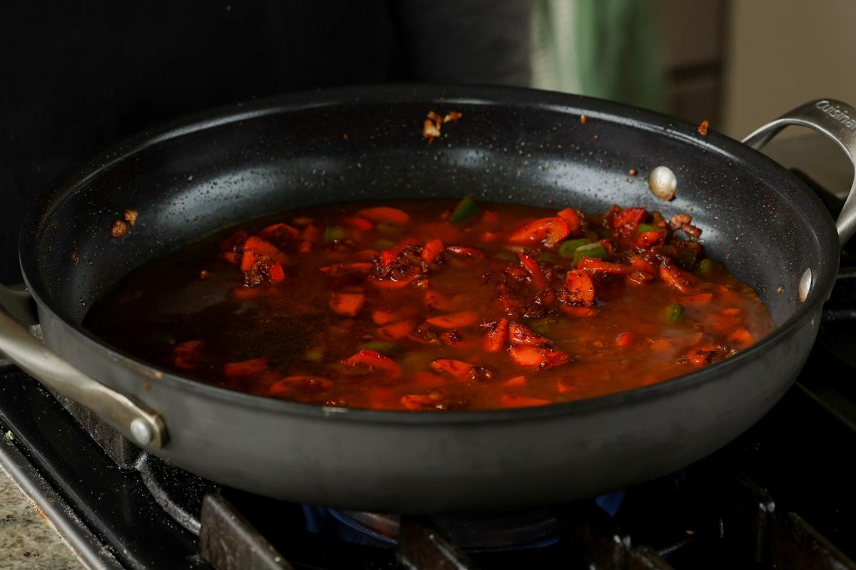 adding water and spices to the pan
