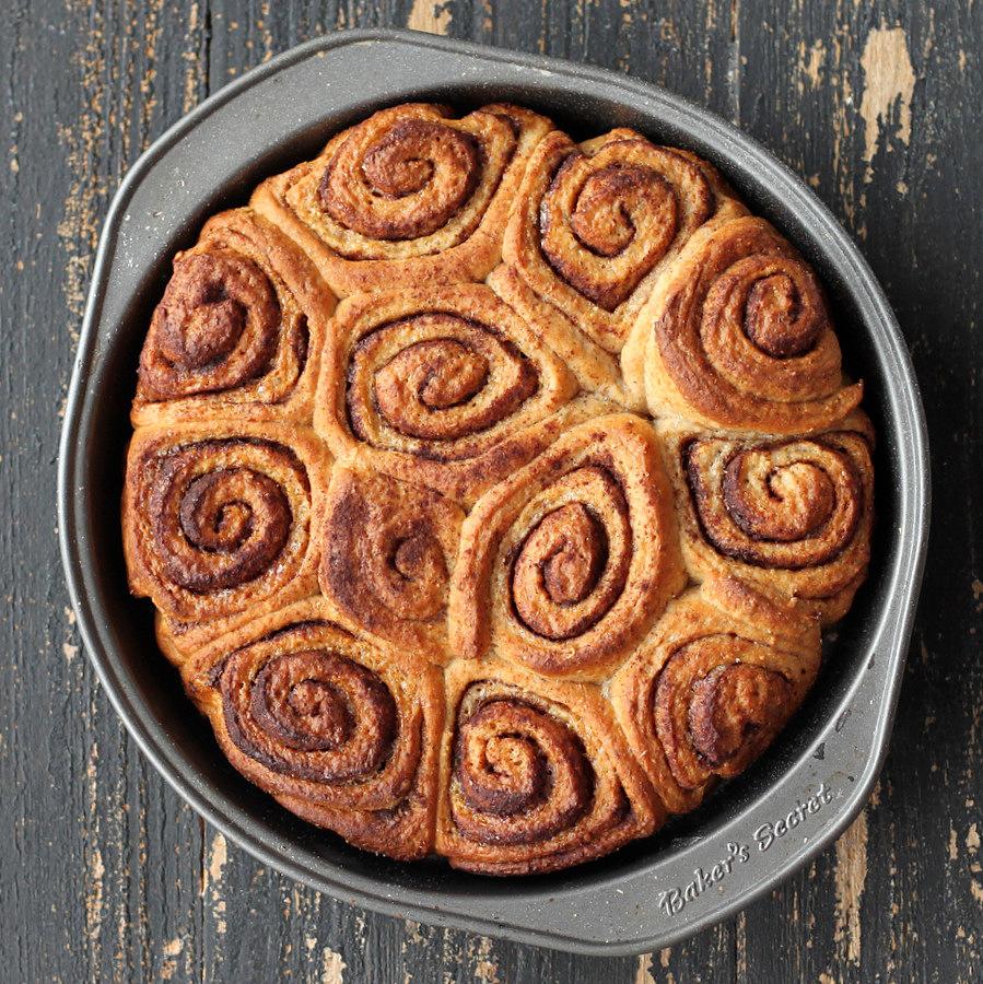 overhead shot of freshly baked Vegan Cinnamon rolls in a round metal cake pan