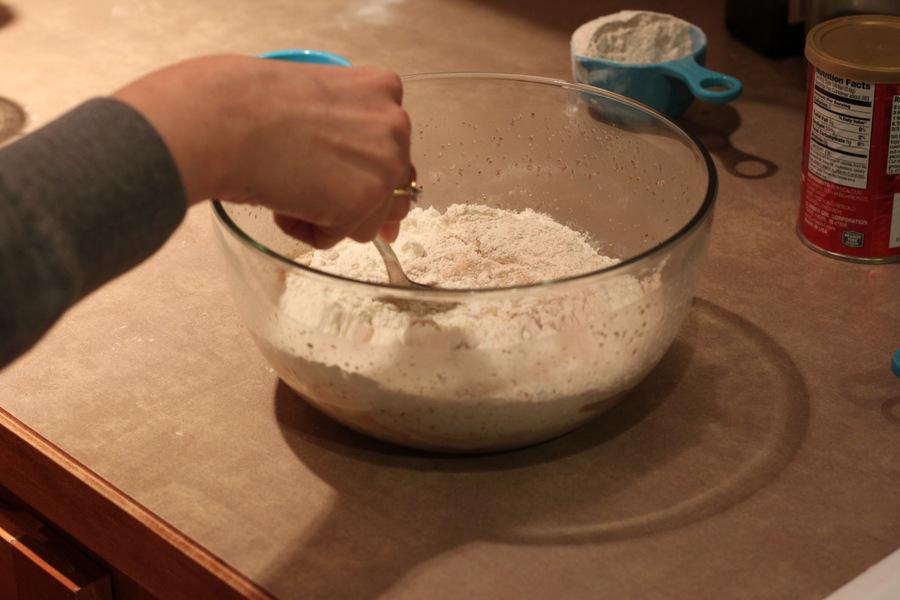 dry ingredients being mixed with activated yeast to make vegan cinnamon rolls recipe