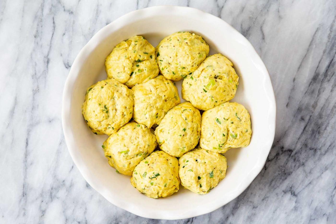 dough balls arranged in a baking dish before baking