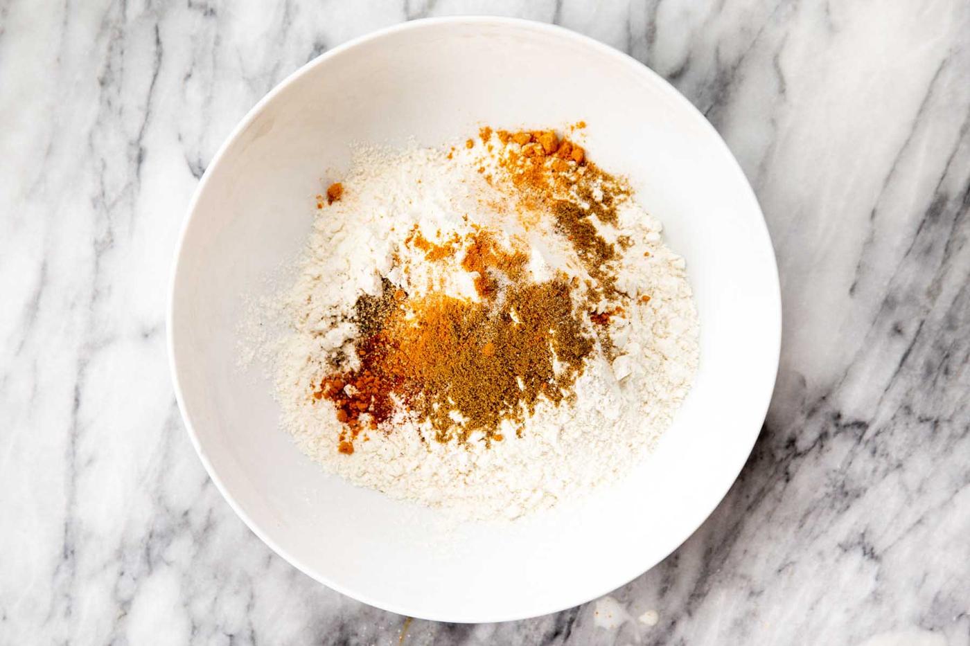 mixing flour and spices in a bowl