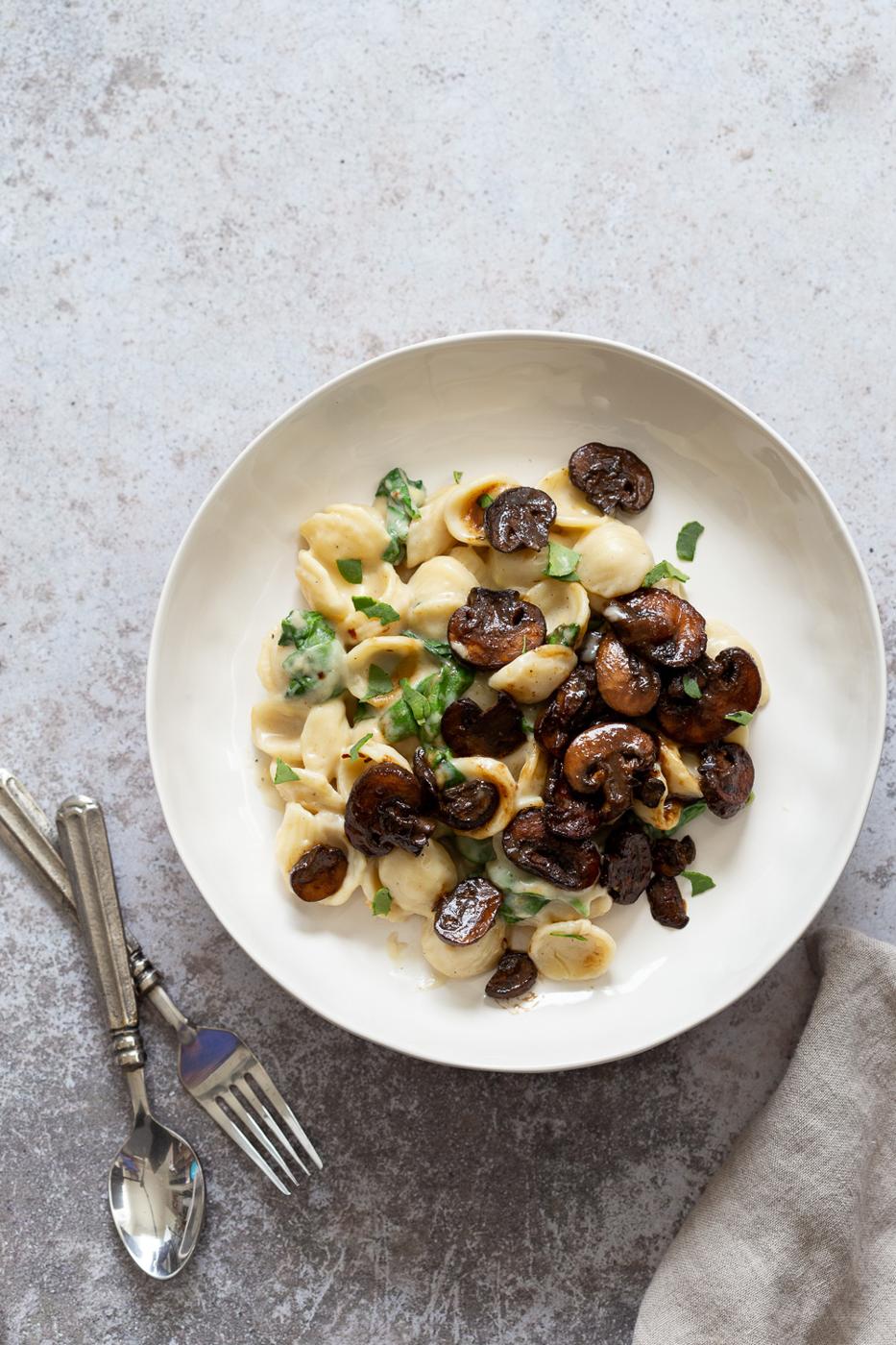 overhead shot of a plate of creamy vegan mushroom and spinach pasta