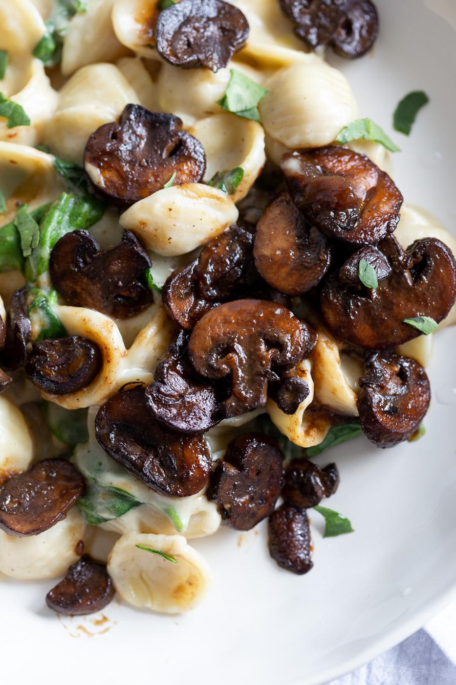 close-up of a plate of pasta with mushrooms and spinach