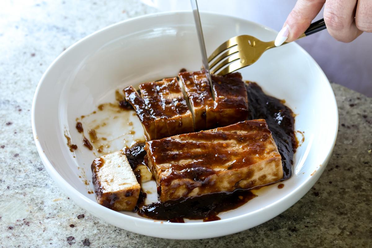 slicing the tofu slabs into strips