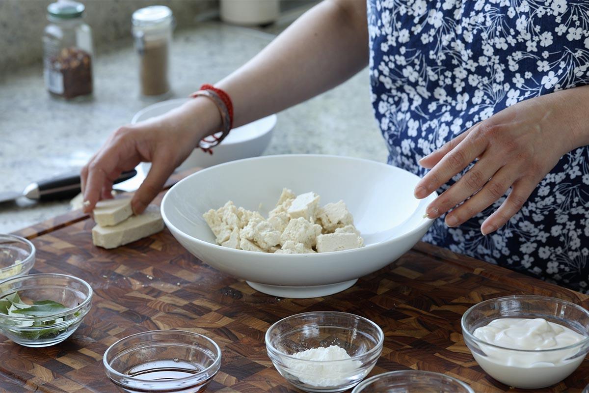 tearing the tofu into bite sized pieces