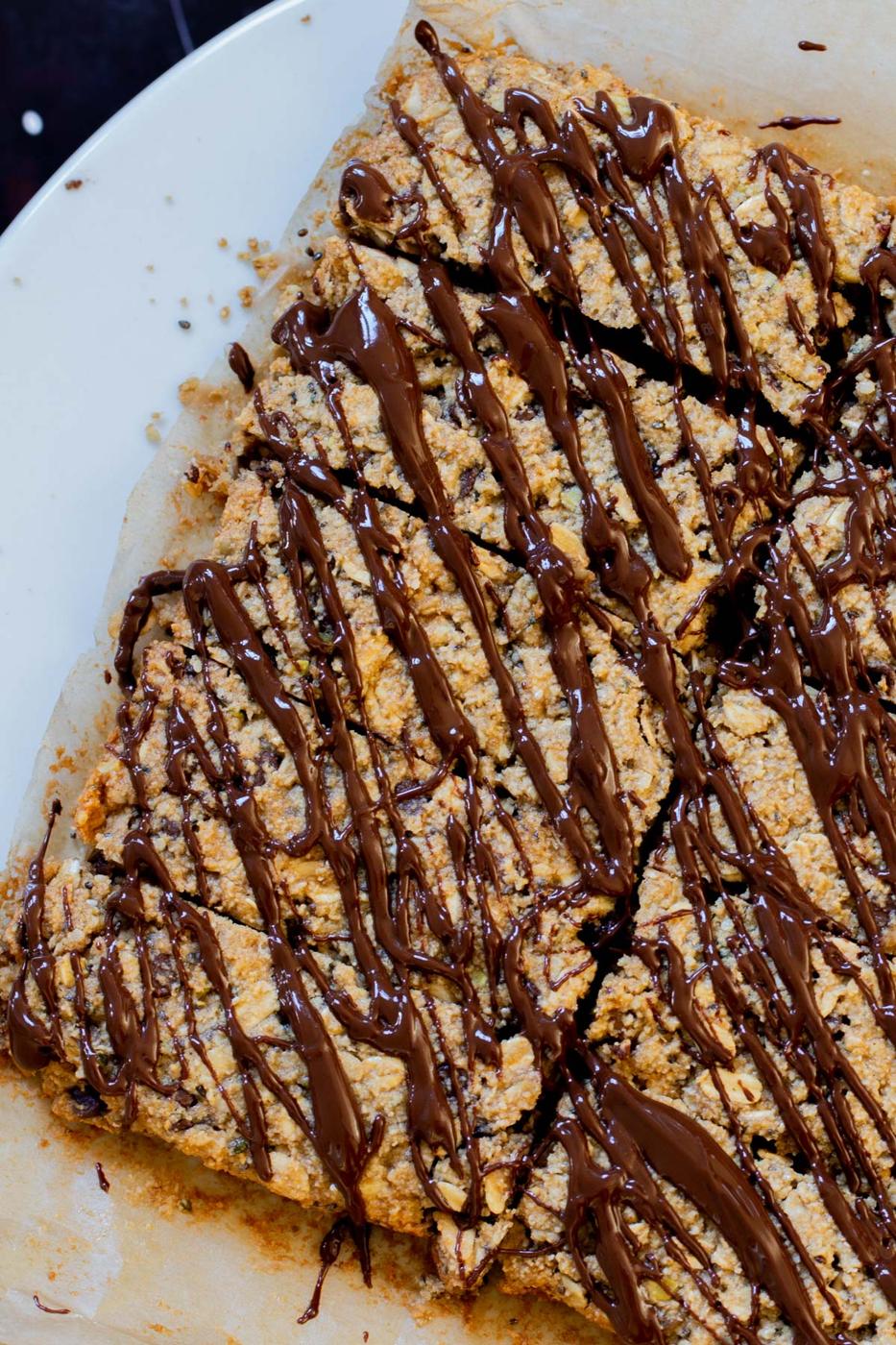 crunchy granola bars with chocolate topping on a white plate