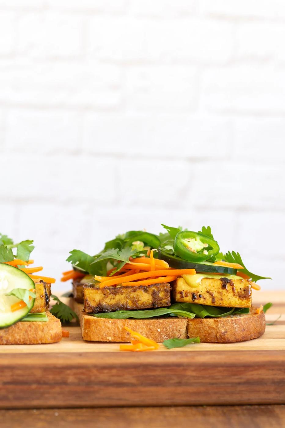 Our Curried Tofu Banh Mi Sandwich assembly on a wood board
