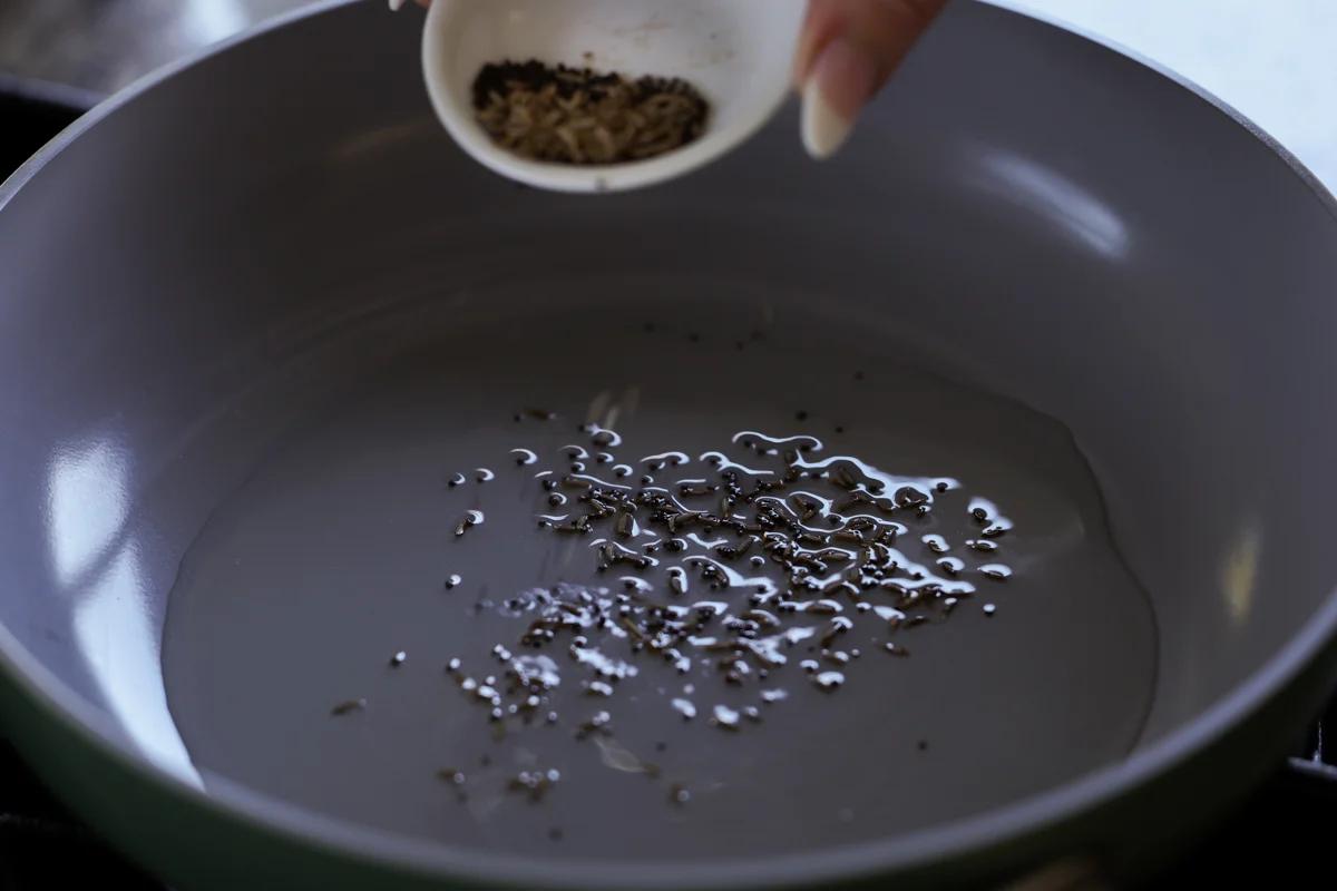adding whole spices to the pan