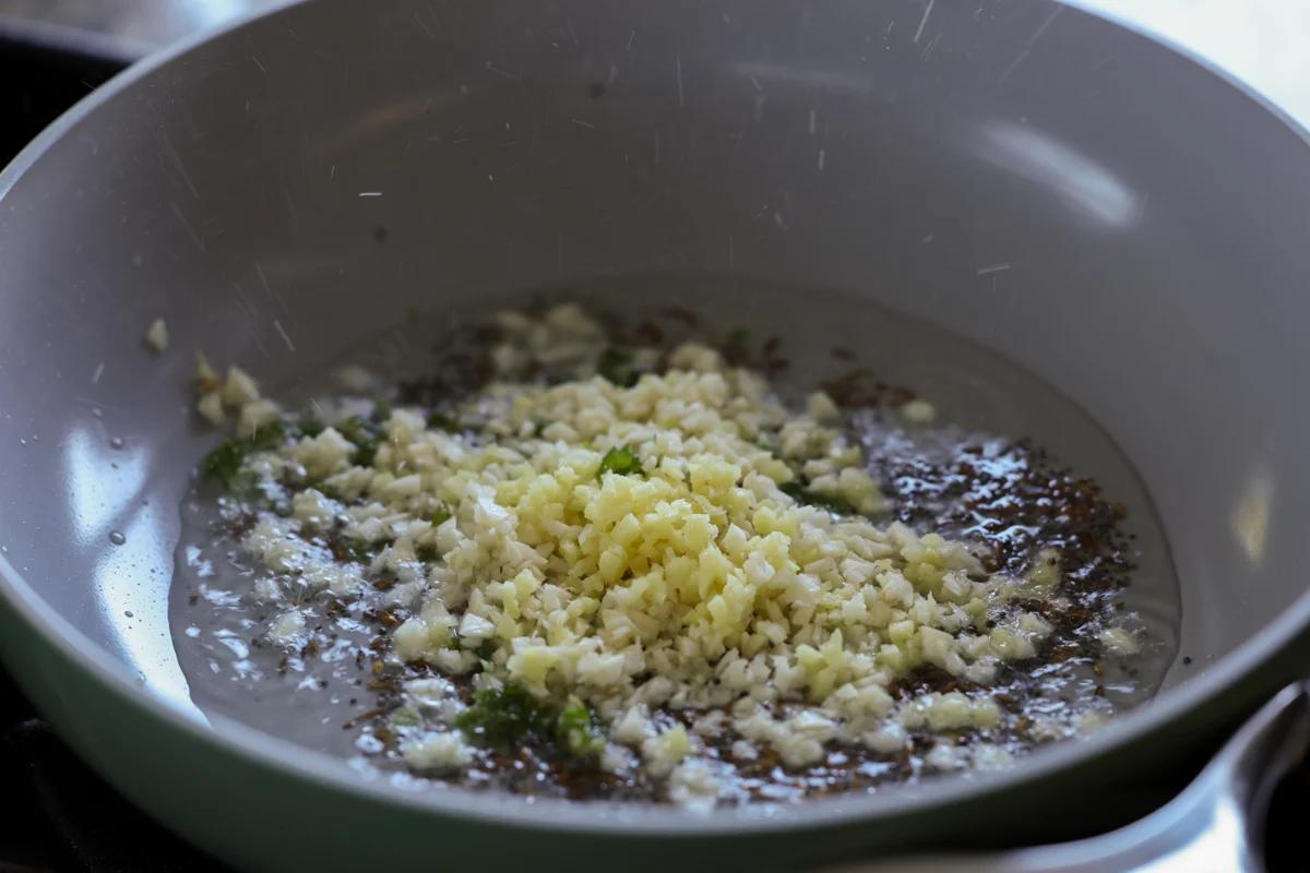 adding garlic to the pan