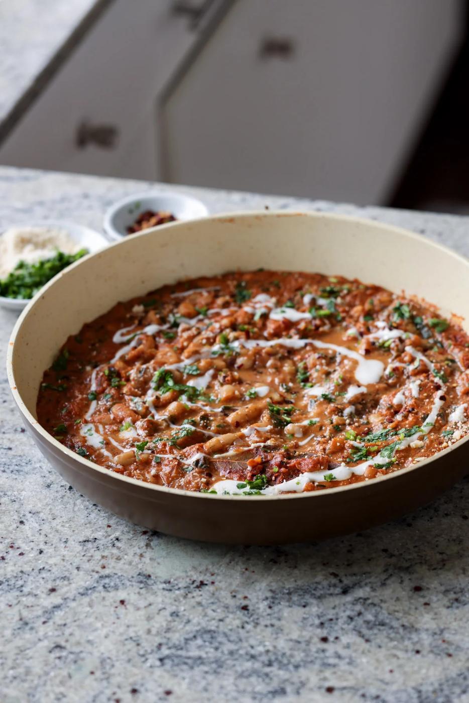 Dhaba chicken white beans in the pan topped with pepper flakes, cilantro, and non-dairy yogurt