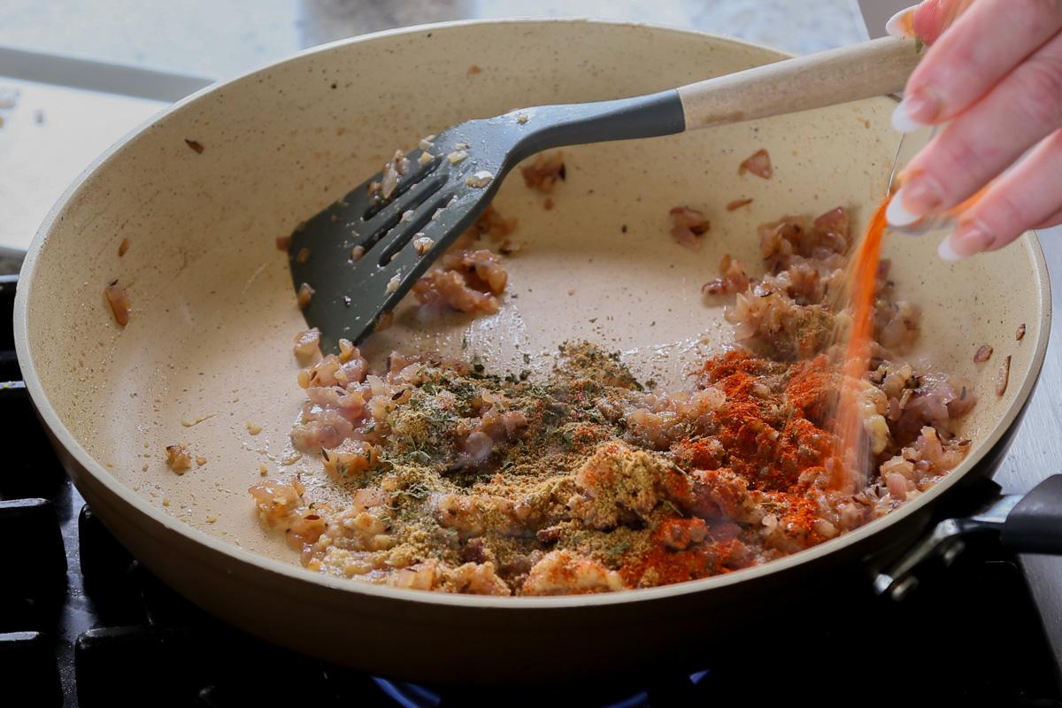 adding dried spices to the pan
