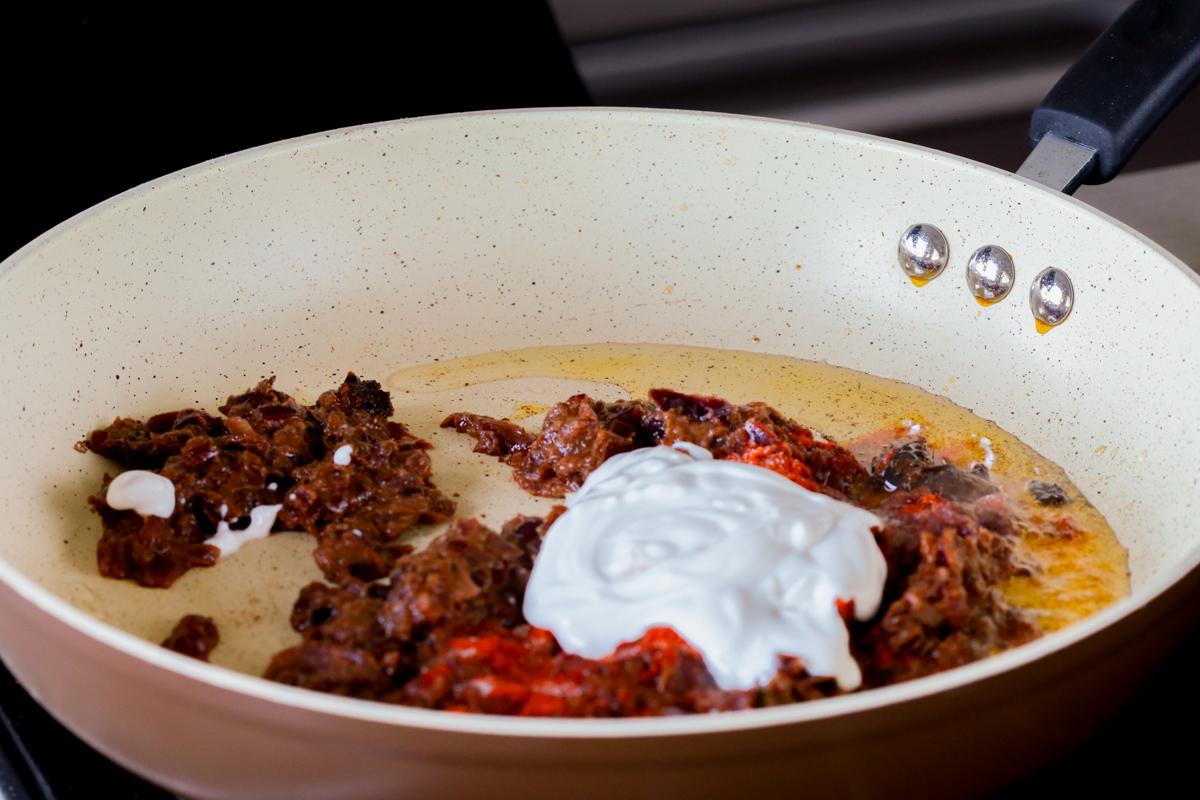 adding yogurt and ground spices to the do pyaza sauce
