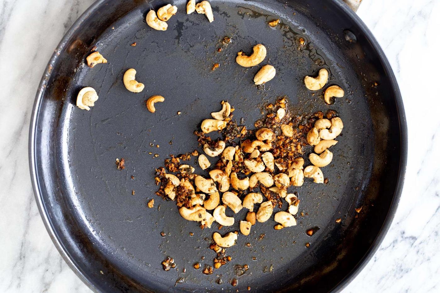 garlic and cashew nuts in a sauteeing pan