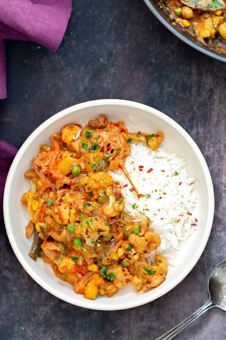 diwani handi vegetables in a white bowl served with a side of rice