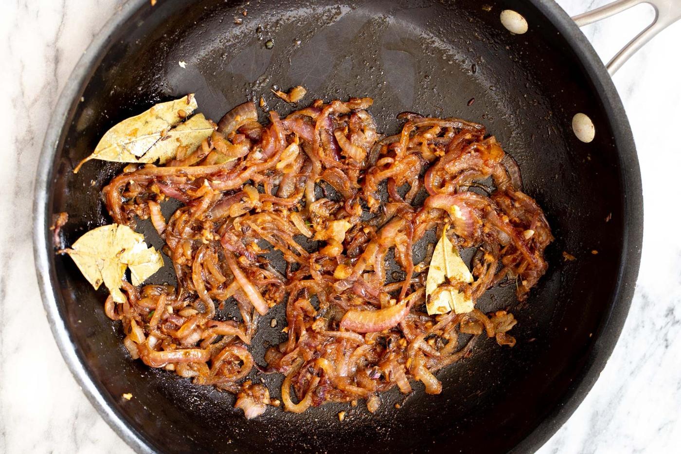 spices and onion being sauteed in a pan