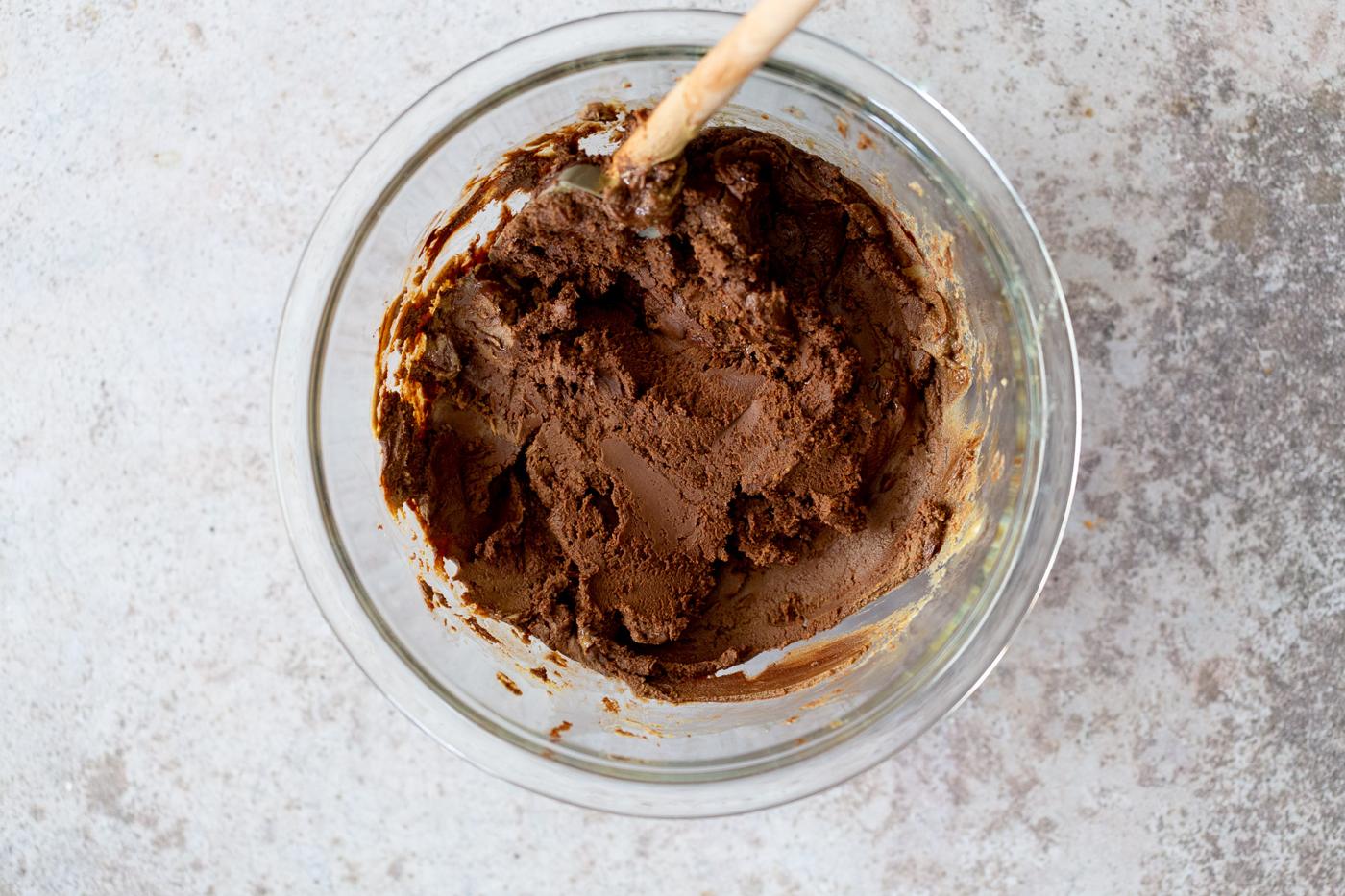 vegan fudge batter being mixed in a glass bowl