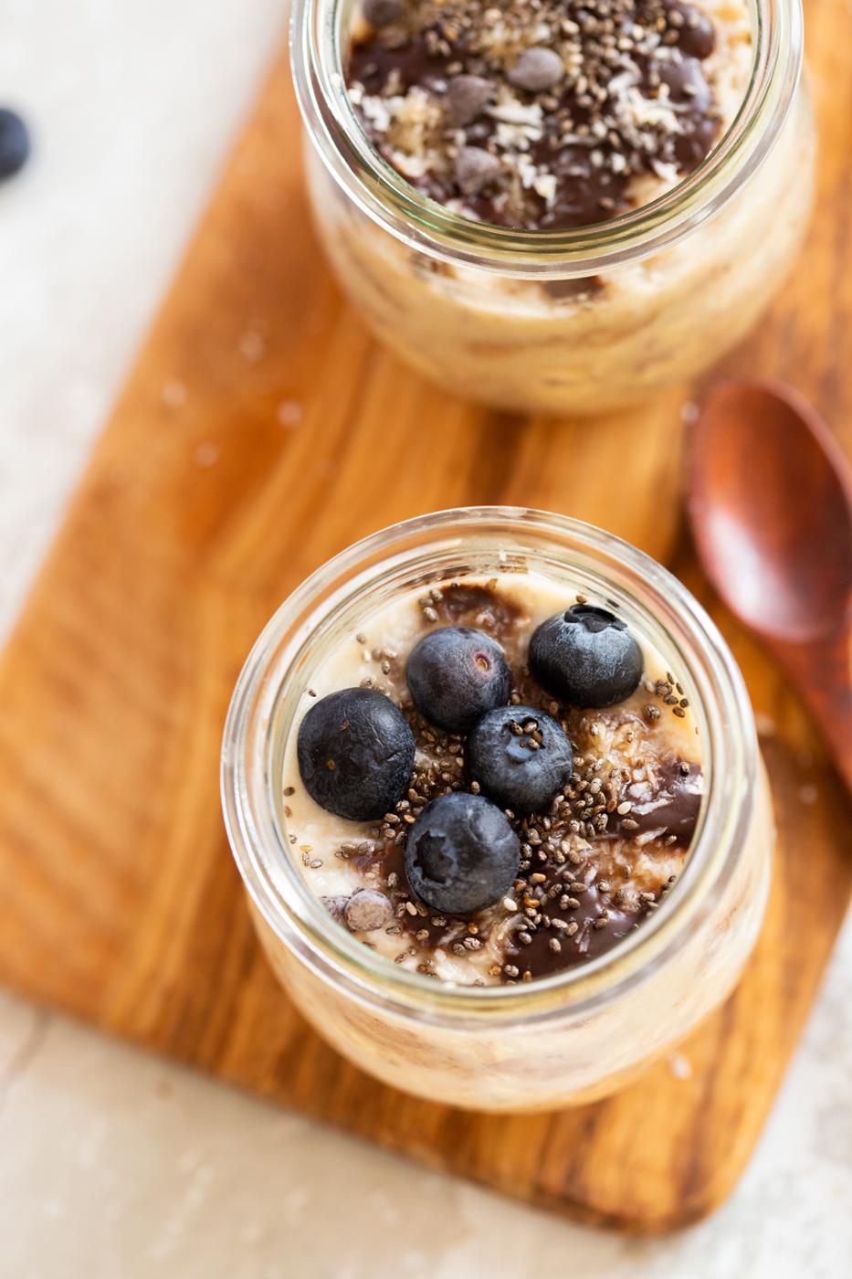 overhead shot of Vegan Samoa Cookie Overnight Oats in glass jars on a wood board