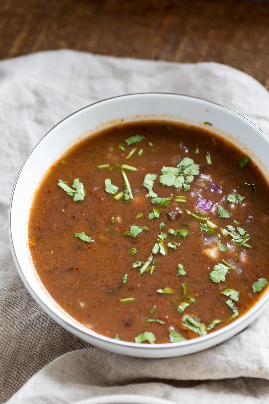 a bowl of vegan Instant Pot black bean soup sprinkled with chopped cilantro