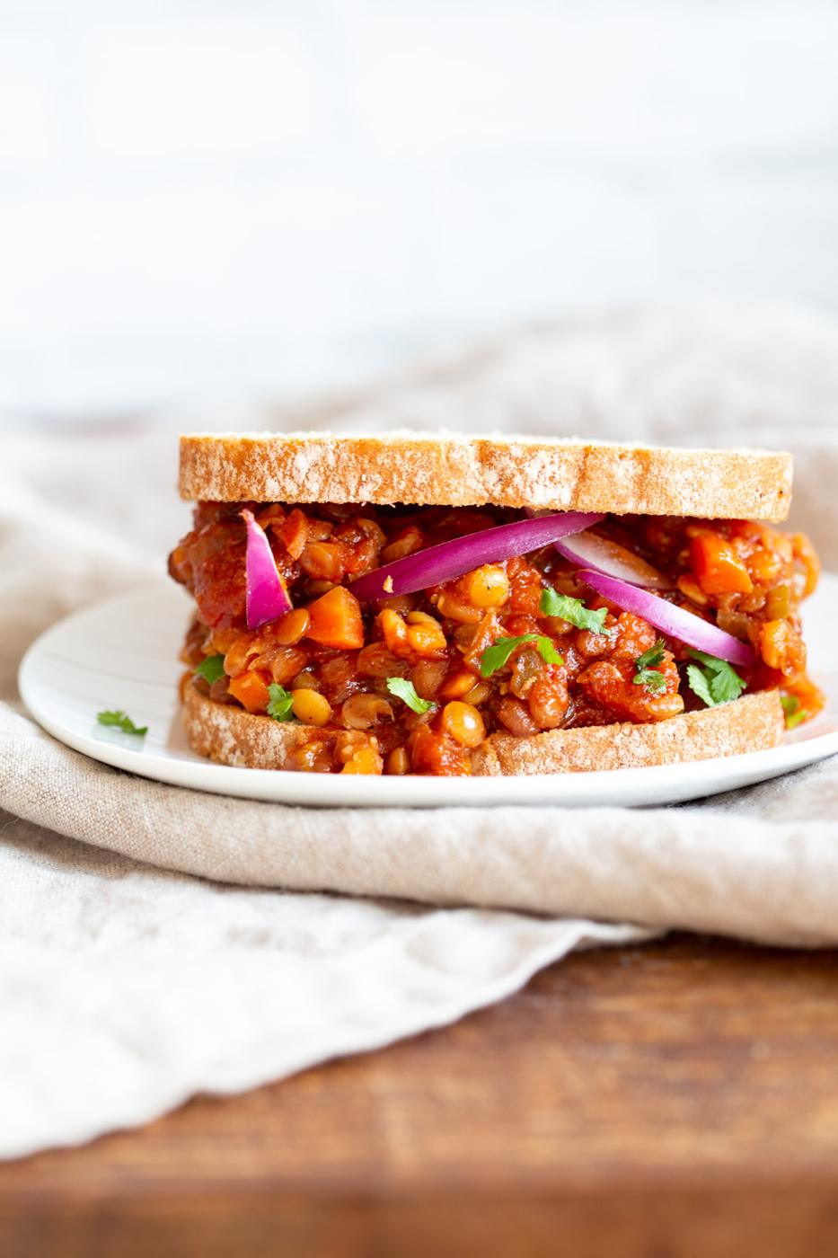 Our Vegan Lentil Sloppy joes serves in a sandwich with onions