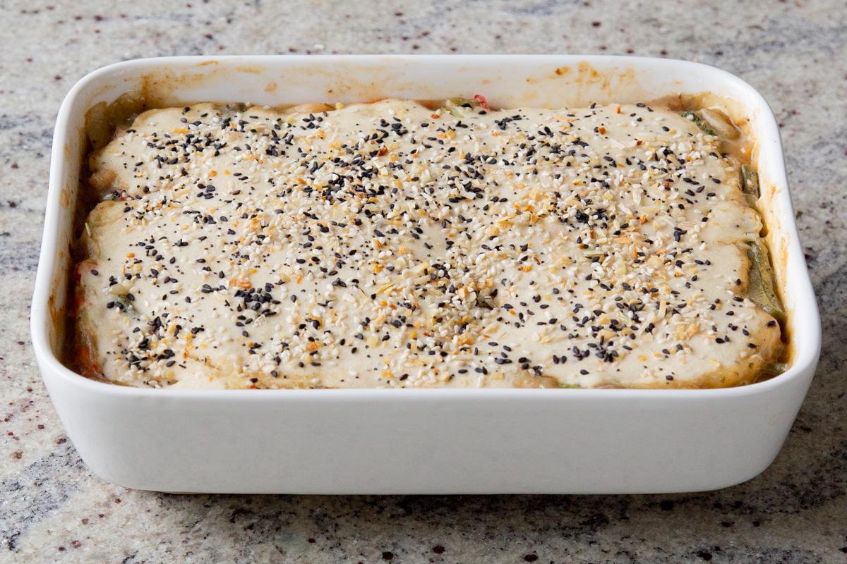 sprinkling everything bagel seasoning on top of the biscuit dough topping