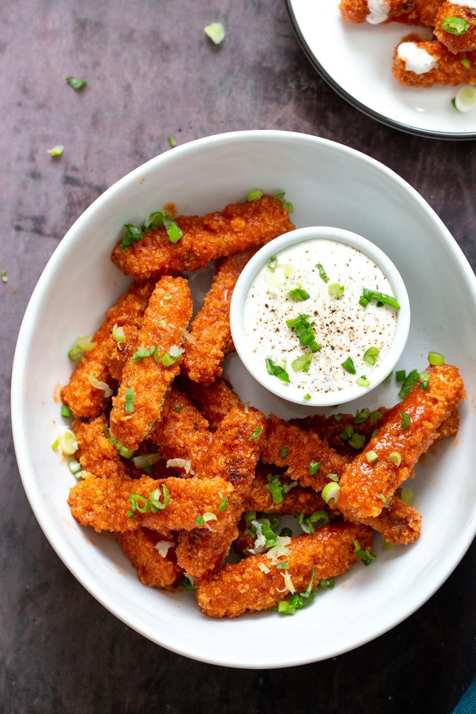 overhead shot of a plate with vegan baked firecracker tofu wings served with side of vegan Ranch