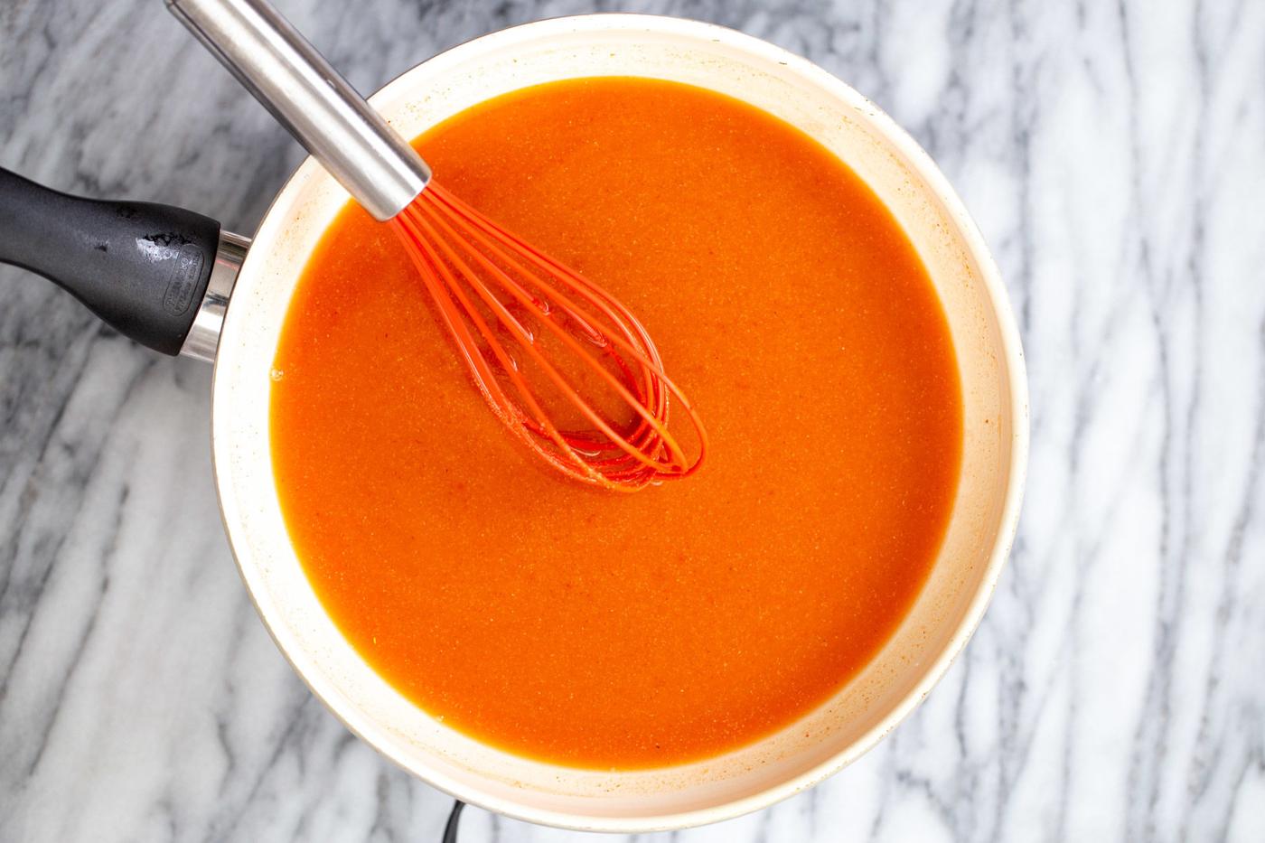 firecracker sauce being stirred together in a white saucepan